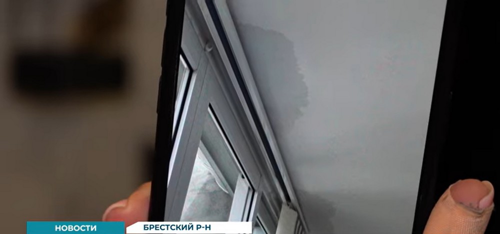 Наталья Монтик показывает на телефоне фото затопленных потолков. Скриншот видео
