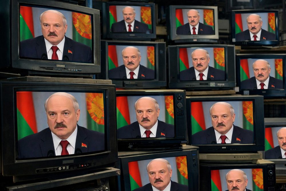 Множество телевизионных экранов с одинаковым официальным выступлением на фоне государственного флага